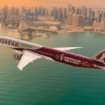 Qatar Airways Airplane Flying over a city