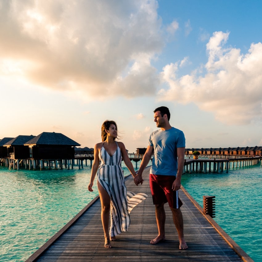 A couple enjoying a sunrise in the Maldives.