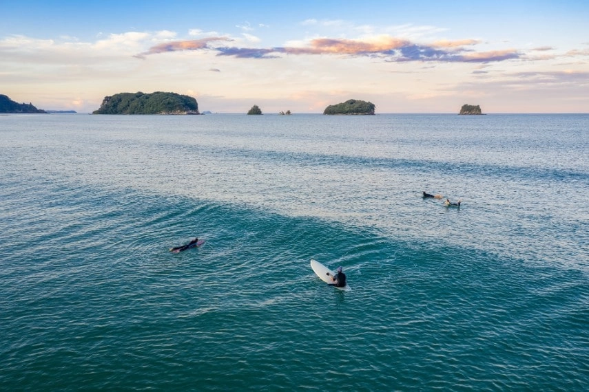 Surfers enjoy the waves in New Zealand in November
