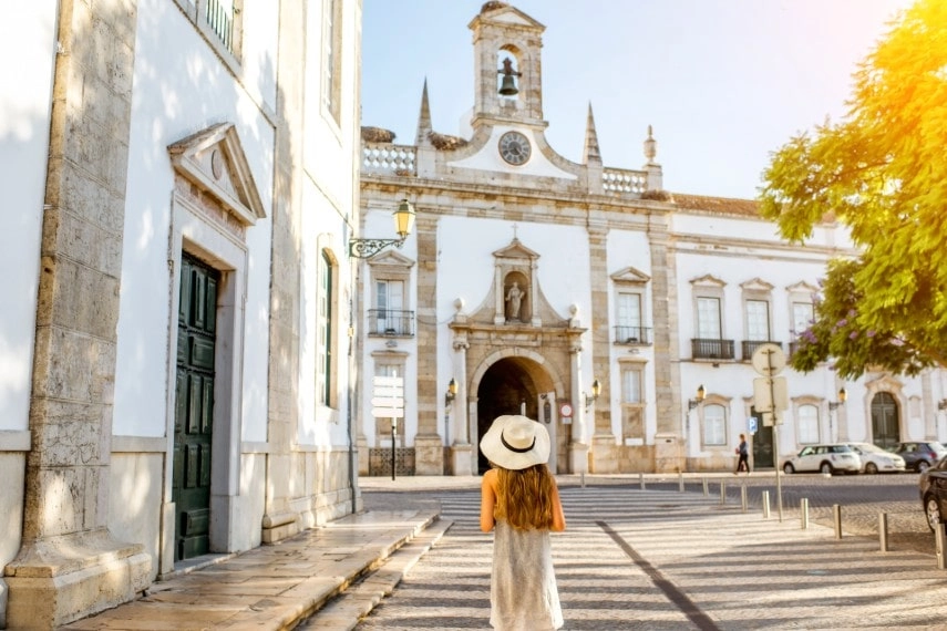 Young woman in front of church, Faro, Portugal visiting in June