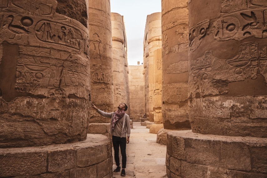 Young man gazing up at Karnak Temple in Luxor Egypt