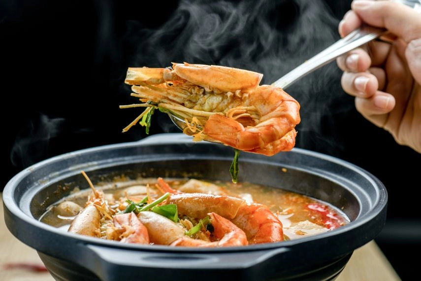 Eat a bowl of tom yum soup with shrimp, mushrooms, and vegetables in Bangkok