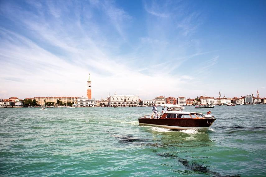 A hotel river shuttle cruises along Venice's Grand Canal