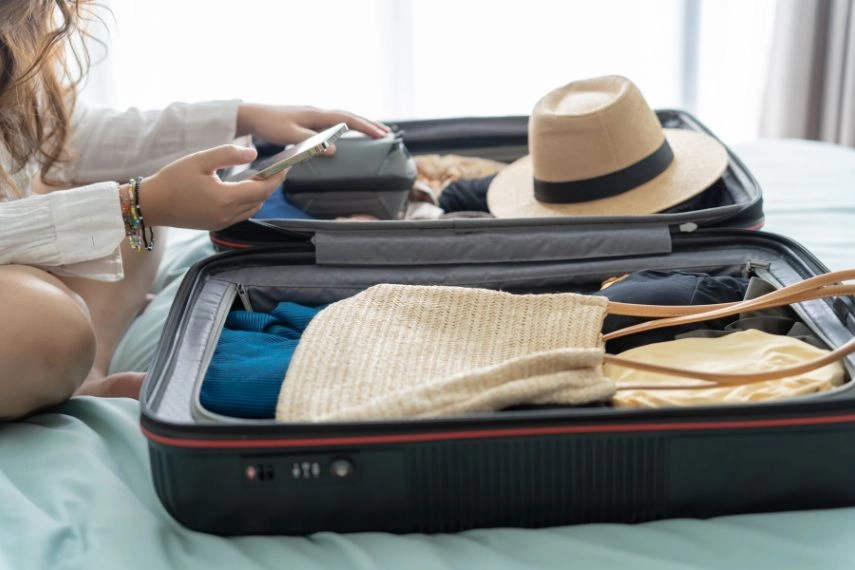 Woman packing suitcase on bed