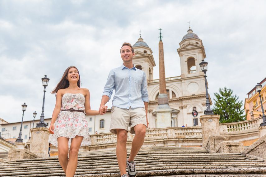 couple wearing linin and cotton comftable clothes and walking down Spanish Steps in Rome