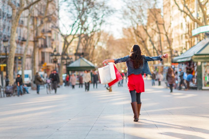 Happy shopping woman walking with bags on Barcelona, La Rambla famous street