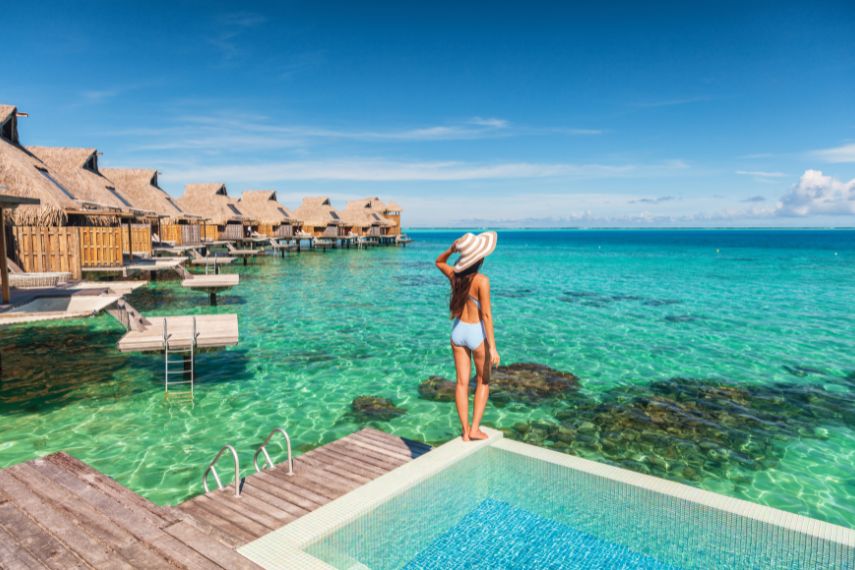 woman in luxury overwater bungalow resort in maldives