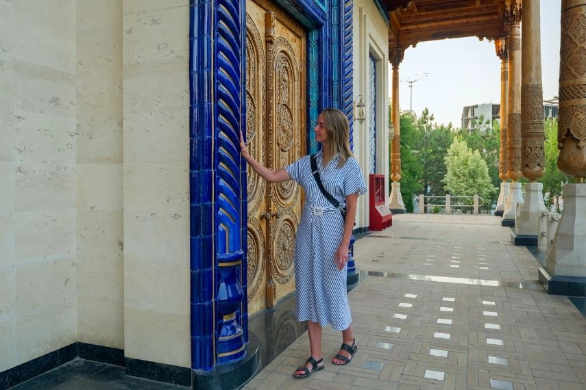 Tourist woman walking and looking to traditonal uzbek ornament